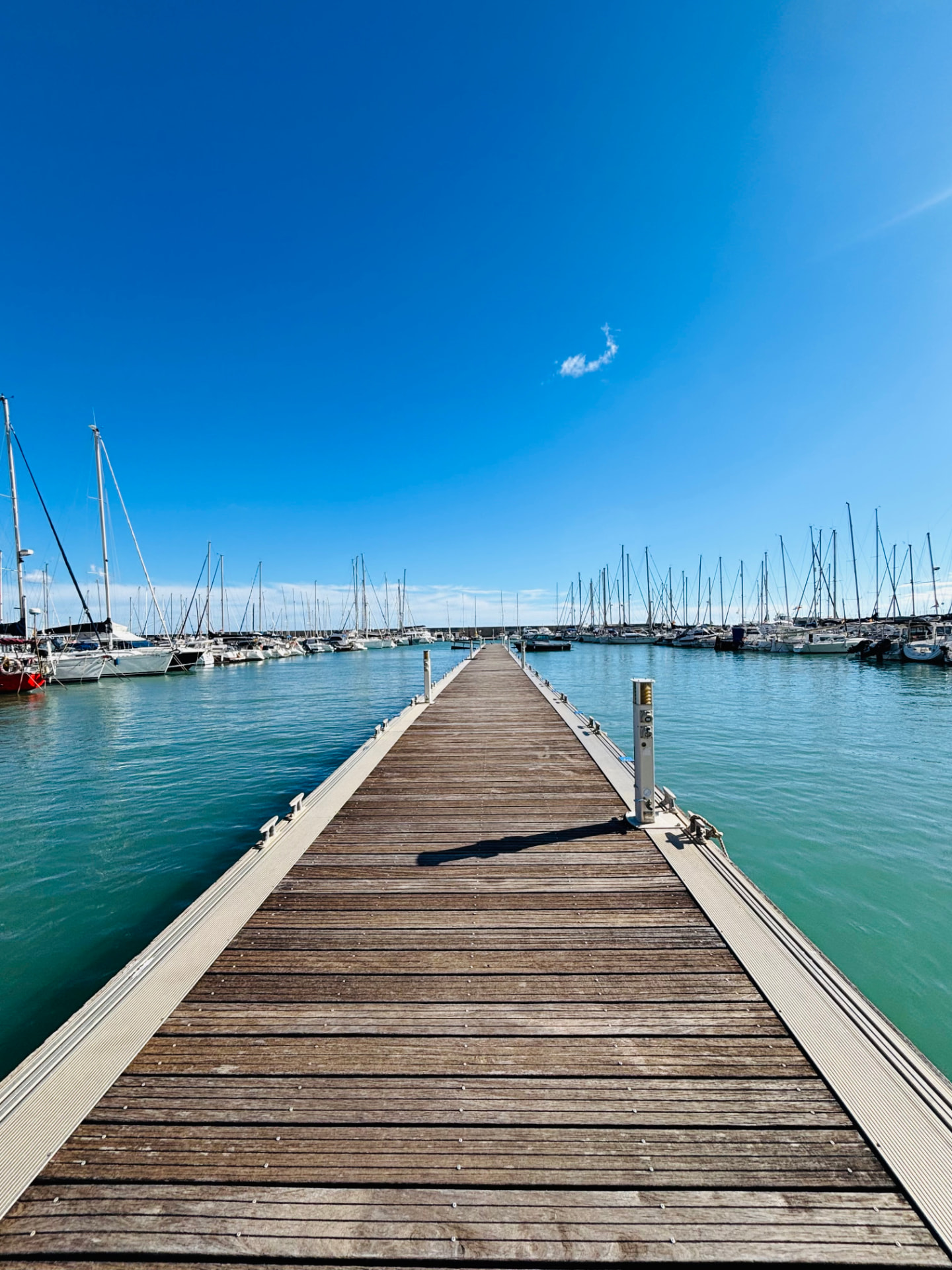 Wooden pontoon reaching into a turquoise Mediterranean marina